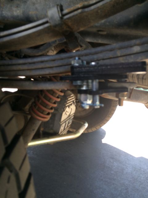 1997 Dodge 3500 - A close-up view of a vehicle's rear suspension system, showing a shock absorber and leaf springs.