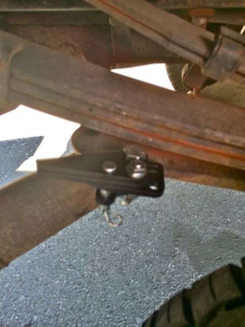 1997 Dodge 3500 - Close-up view of a black metal part with a hook, attached to the undercarriage of a vehicle.