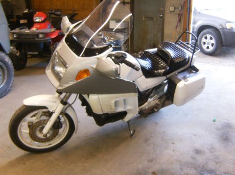 2000 Ford E350 - A white motorcycle is parked in a garage, with other vehicles visible in the background.