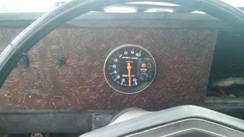 1979 Ford Bronco - Interior view of a vehicle's dashboard a tachometer and decorative paneling, with a SuperMotors watermark visible.