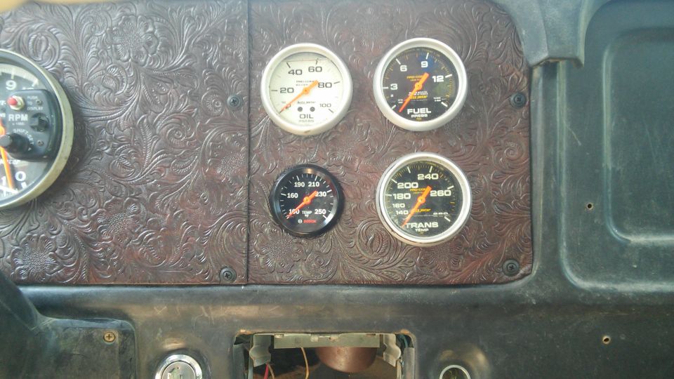 Dashboard with oil, fuel, transmission, and RPM gauges. The dash panel has a tooled leather-like pattern