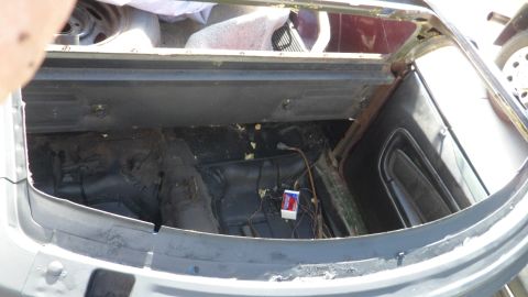 1972 Ford Ranchero - The interior of a vehicle's trunk area shows exposed wiring and a small white box with red and blue markings.