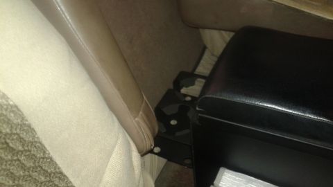 1996 Ford Bronco - This image shows the interior of a vehicle, focusing on the area between the driver and passenger seats. A black center console with a cuph…