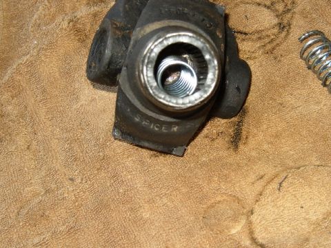 1989 Ford Bronco - A close-up view of a Dana Spicer U-joint part, showing internal components and a separate spring.