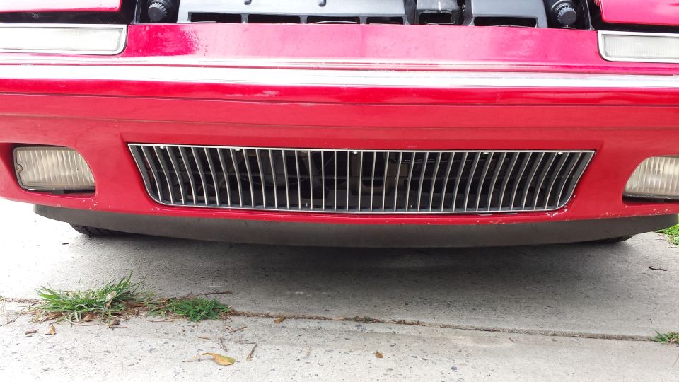 Red car front with chrome grille and fog lights