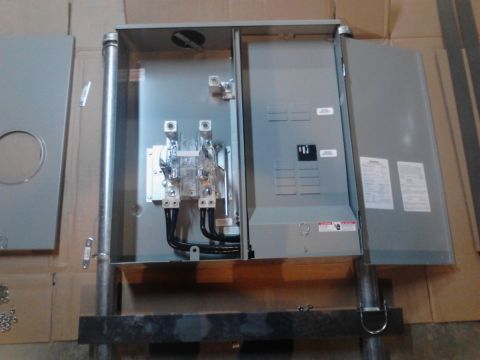 1989 Ford Bronco - An open electrical panel box with circuit breakers and wiring is shown. The panel is mounted on a metal conduit pipe.