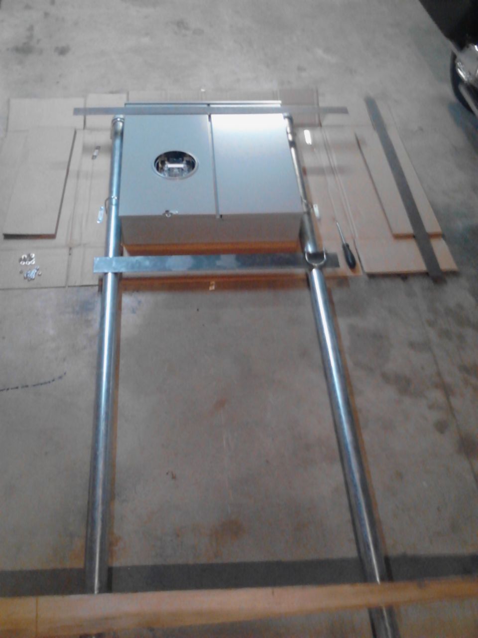 Overhead view of a gray electrical box on a metal frame on a concrete floor.