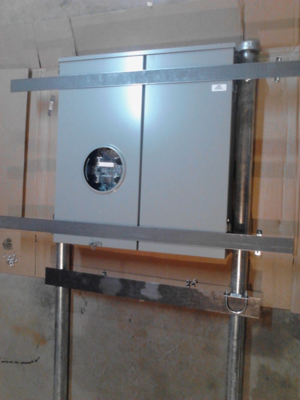 Gray electrical meter box with bracing and conduit