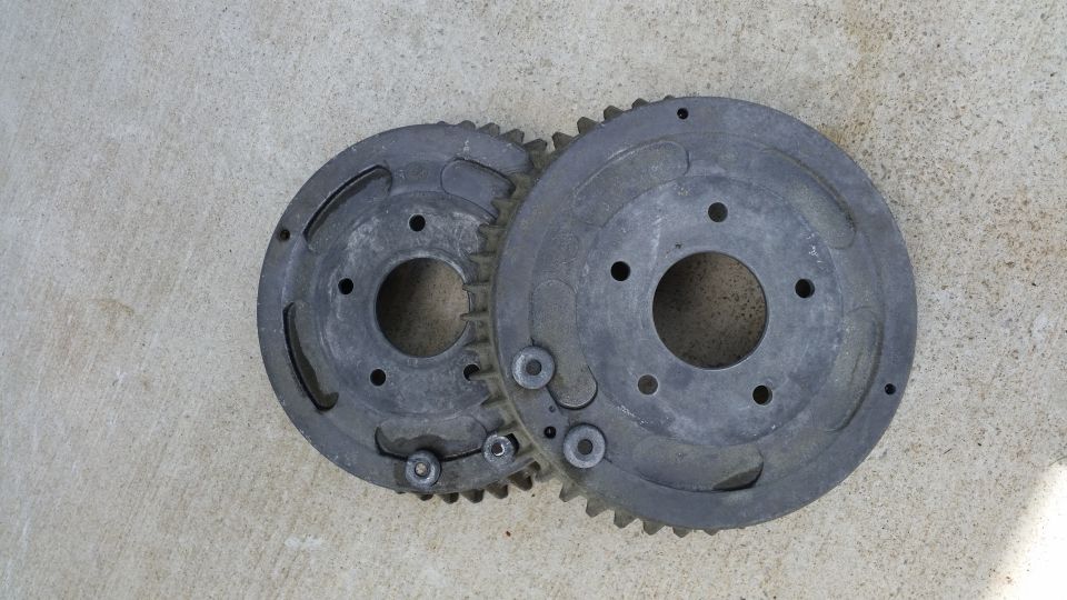 Two metal gears with teeth and bolt holes