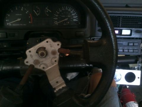 1991 Honda CRX - The steering column is exposed, revealing the mounting bracket and wiring beneath the dashboard.