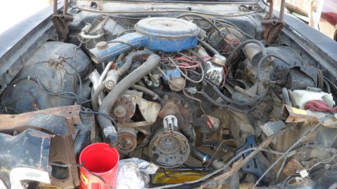 1972 Ford Ranchero - The engine compartment of a vehicle shows a complex arrangement of hoses, wires, and engine components.