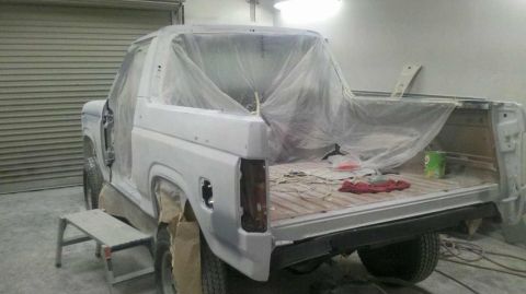1982 Ford Bronco - Ford Bronco in a body shop, prepped for paint with doors off and covered.