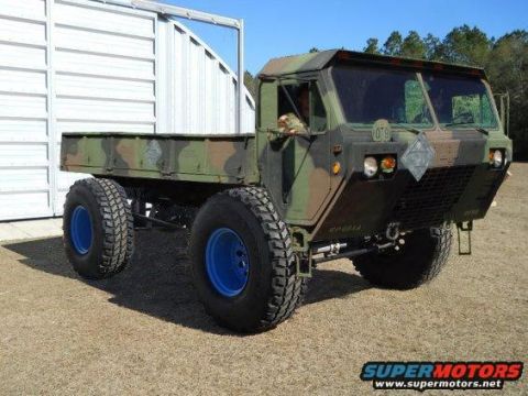 1992 Ford Bronco - This military truck features a camouflage paint scheme and striking blue rims, presented from a three-quarter front perspective.