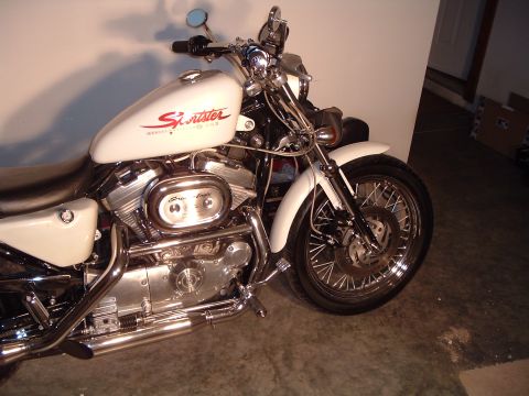 2011 Harley-Davidson Elec Gld Police - A white Harley-Davidson Sportster motorcycle is parked indoors, showing its engine and front wheel.