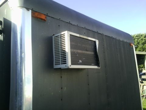 1991 Honda CRX - A window air conditioning unit is installed on the exterior of a dark-colored trailer.