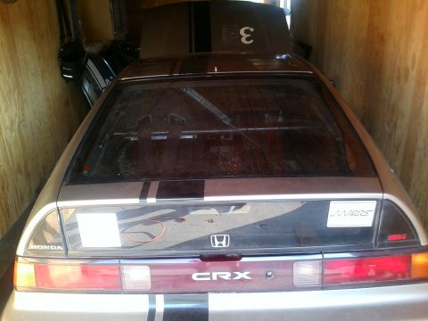 1991 Honda CRX - Rear view of a 1991 Honda CRX, showing racing stripes and the CRX badge.