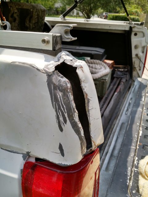 1992 Ford Bronco - This damaged fender flare on a pickup truck bed reveals significant body damage and crude repair attempts.