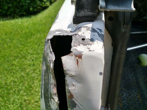 1992 Ford Bronco - This damaged vehicle body panel shows significant structural compromise and rust.
