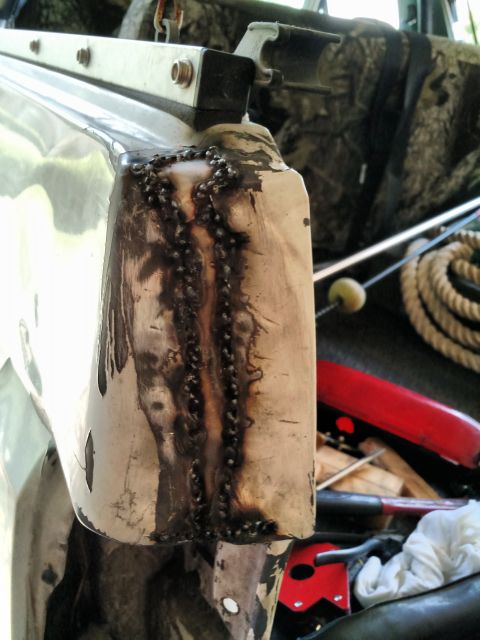 1992 Ford Bronco - Close-up of a damaged and repaired metal panel on a vehicle, with tools and rope in the background.