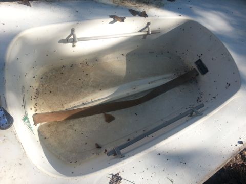 1973 Ford F-100 - The interior of a white boat hull shows signs of wear and tear, with debris scattered inside.