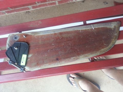 1973 Ford F-100 - A wooden boat part with a black bracket is shown resting on red benches.