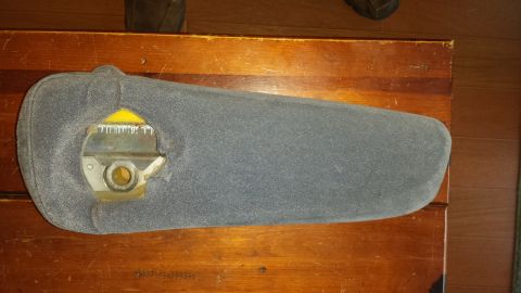 1995 Ford Bronco - A gray sun visor with visible internal components rests on a wooden surface.