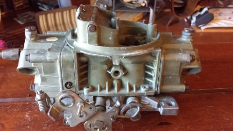 1995 Ford Bronco - Holley carburetor shown on a wooden surface. Text "HOLLEY" is visible on the part.