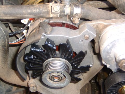 1987 Ford Bronco - Close-up of an automotive alternator, showing the fan and pulley assembly.