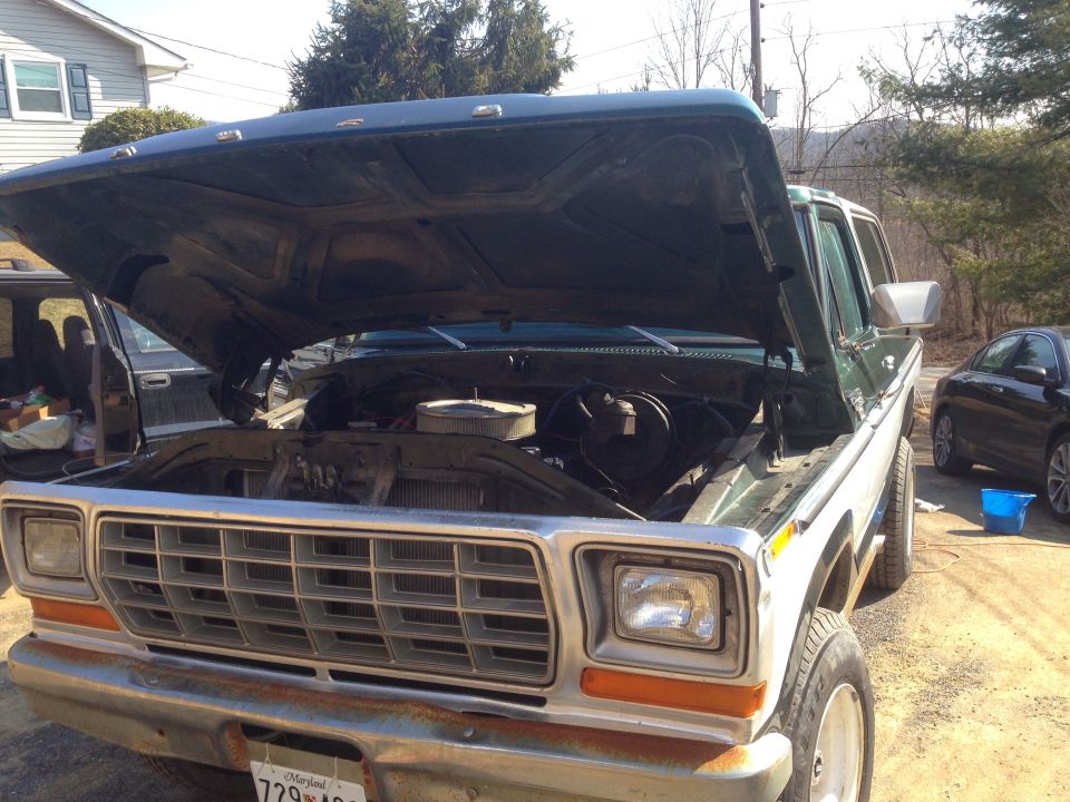 Green and white 1978 Ford Bronco with hood open, showing engine bay. Front grille and headlights visible
