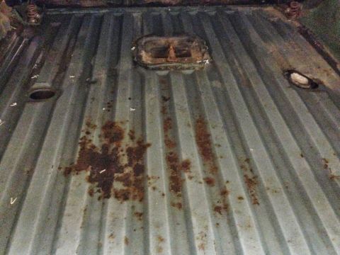1979 Ford Bronco - Close-up of a rusty, corrugated metal floor inside a vehicle.
