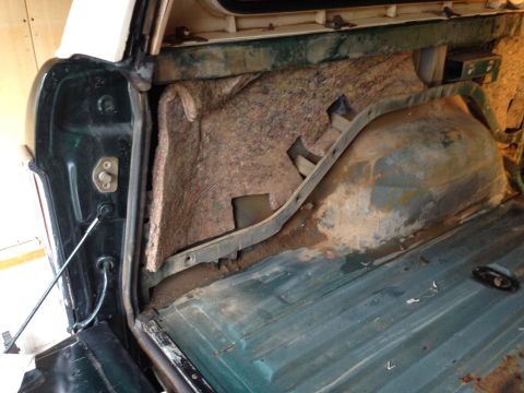 1979 Ford Bronco - The interior cargo area of a 1978 Ford Bronco shows exposed insulation and signs of rust.