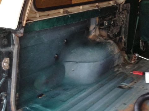 1979 Ford Bronco - The cargo area of a 1979 Ford Bronco shows its dark green interior panels and wheel well.