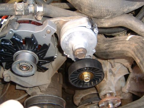 1987 Ford Bronco - Close-up view of the alternator and belt tensioner pulley assembly within an engine bay.
