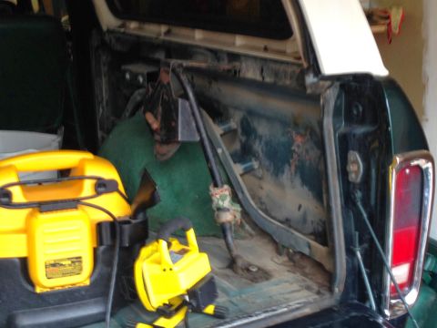 1979 Ford Bronco - The interior of a 1979 Ford Bronco is shown with cleaning equipment, including a yellow shop vac and a work light.