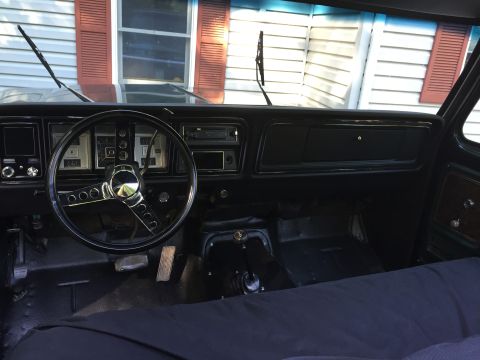 1979 Ford Bronco - The interior of a 1979 Ford Bronco shows its dashboard, steering wheel, and floor.