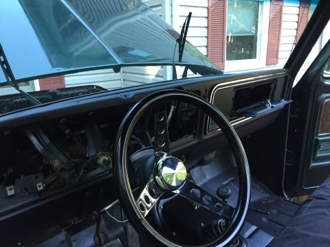 1979 Ford Bronco - The dashboard of a 1979 Ford Bronco is partially disassembled, revealing exposed wiring and a custom steering wheel.