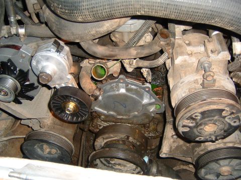 1987 Ford Bronco - Engine bay view of a water pump, alternator, and accessory drive components with visible coolant leaks.