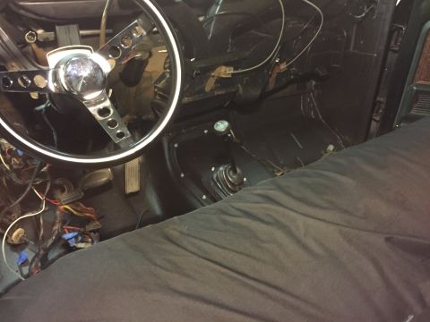 1979 Ford Bronco - The interior of a classic vehicle, likely a 1979 Ford Bronco, is shown from the driver's perspective. Visible elements include a chrome ste…