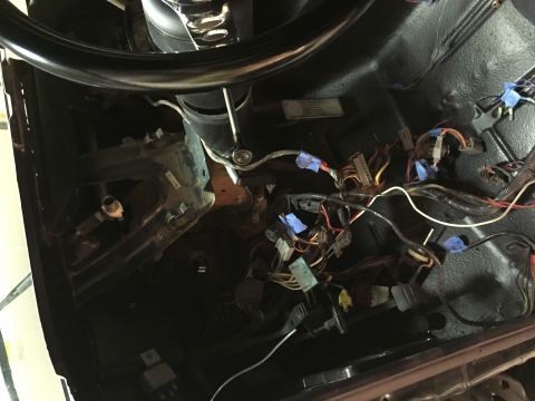 1979 Ford Bronco - A close-up view of the wiring harness and steering column area of a vintage vehicle, likely a 1979 Ford Bronco, with various connectors and…