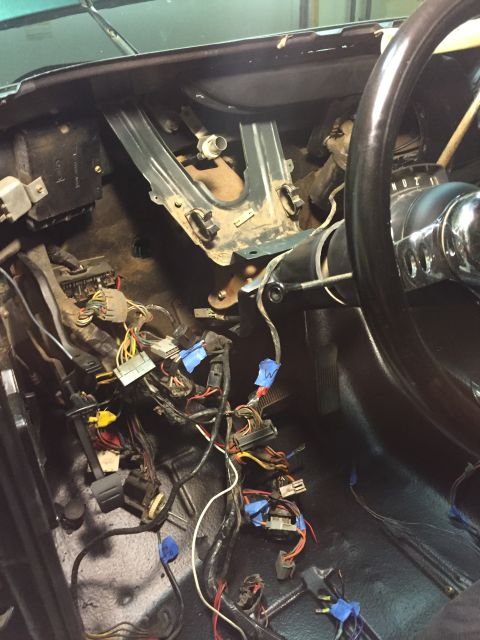 1979 Ford Bronco - The interior of a 1979 Ford Bronco shows a disassembled dashboard with exposed wiring and components. A steering wheel and part of the driv…
