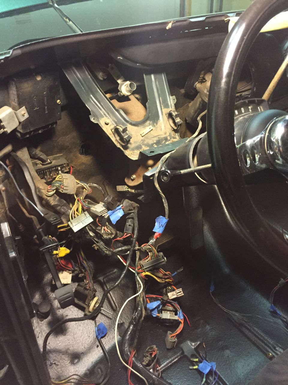 1979 Ford Bronco interior with exposed wiring and steering wheel.