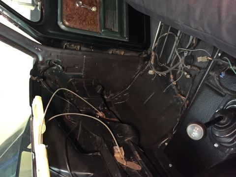 1979 Ford Bronco - Interior view of a vintage vehicle, likely a 1979 Ford Bronco, showing the floor area with exposed wiring, a transfer case shifter, and par…