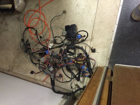 1979 Ford Bronco - A tangled mess of automotive wiring harness and a black control module lies on a concrete floor.
