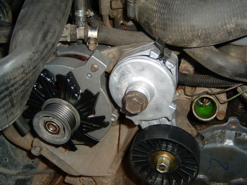 Alternator, pulley, and tensioner assembly with green coolant visible