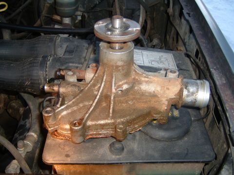 1987 Ford Bronco - A heavily rusted water pump sits in the engine bay, likely needing replacement.