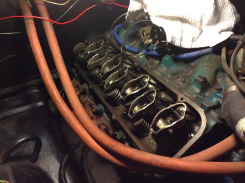 1979 Ford Bronco - A close-up view of the valve train of a V8 engine, likely from a classic Ford Bronco, showing the rocker arms and valve springs. Two orange…