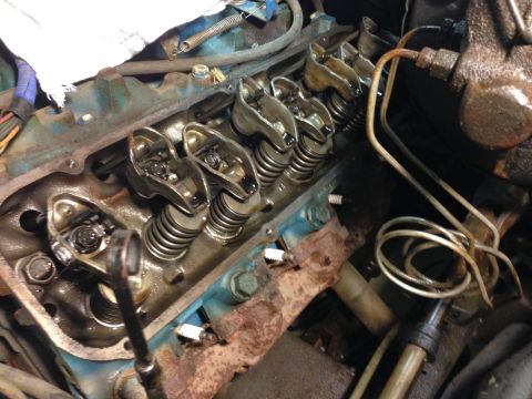 1979 Ford Bronco - The image shows a close-up view of the internal components of a V8 engine, specifically the valve train with rocker arms and valve springs…