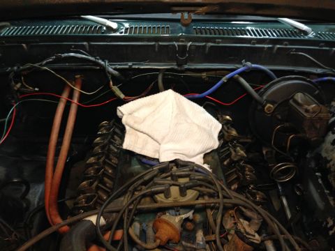 1979 Ford Bronco - The engine bay of a classic Ford Bronco is shown, with the valve covers exposed and a white towel placed over part of the engine. Various h…
