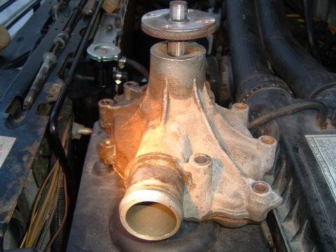 1987 Ford Bronco - Water pump removed from an engine bay, showing the main housing and shaft.