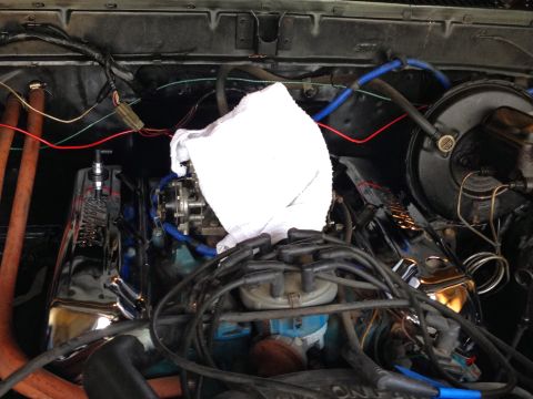 1979 Ford Bronco - A close-up view of a V8 engine bay, likely from a 1979 Ford Bronco, showing chrome valve covers, a carburetor, and various hoses and wiring.